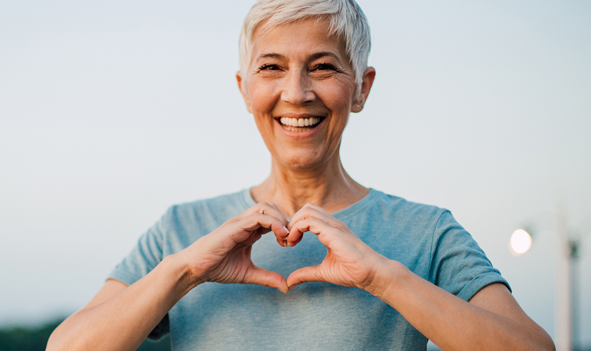 senior woman making heart with hands